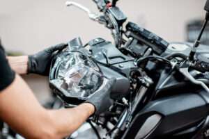 Worker repairing motorcycle headlight in the workshop